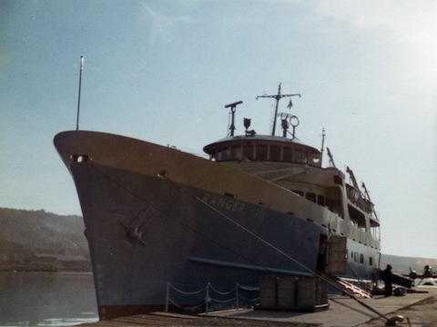 The bow of the light blue colored
           ferry is seen against the sun and a blue sky.