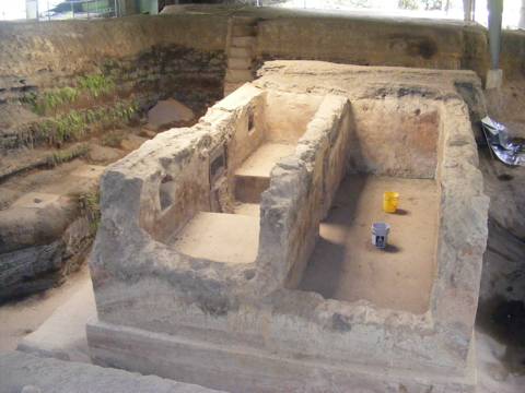 A two-room house with a door (filled with
                 ash) into the room on the left and 
                 with sleeping platforms on either side 
                 of the door. The walls are very thick. 
                 Two pails in the room on the right show
                 the scale.