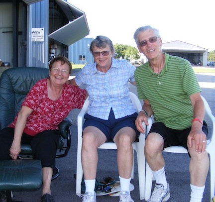 We are seated in the shade of the hanger and smiling.