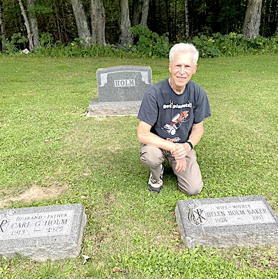 Al kneels on one knee behind his mother’ss stone. His dad’ss stone is 
           to theh left and the Holm monument behind him