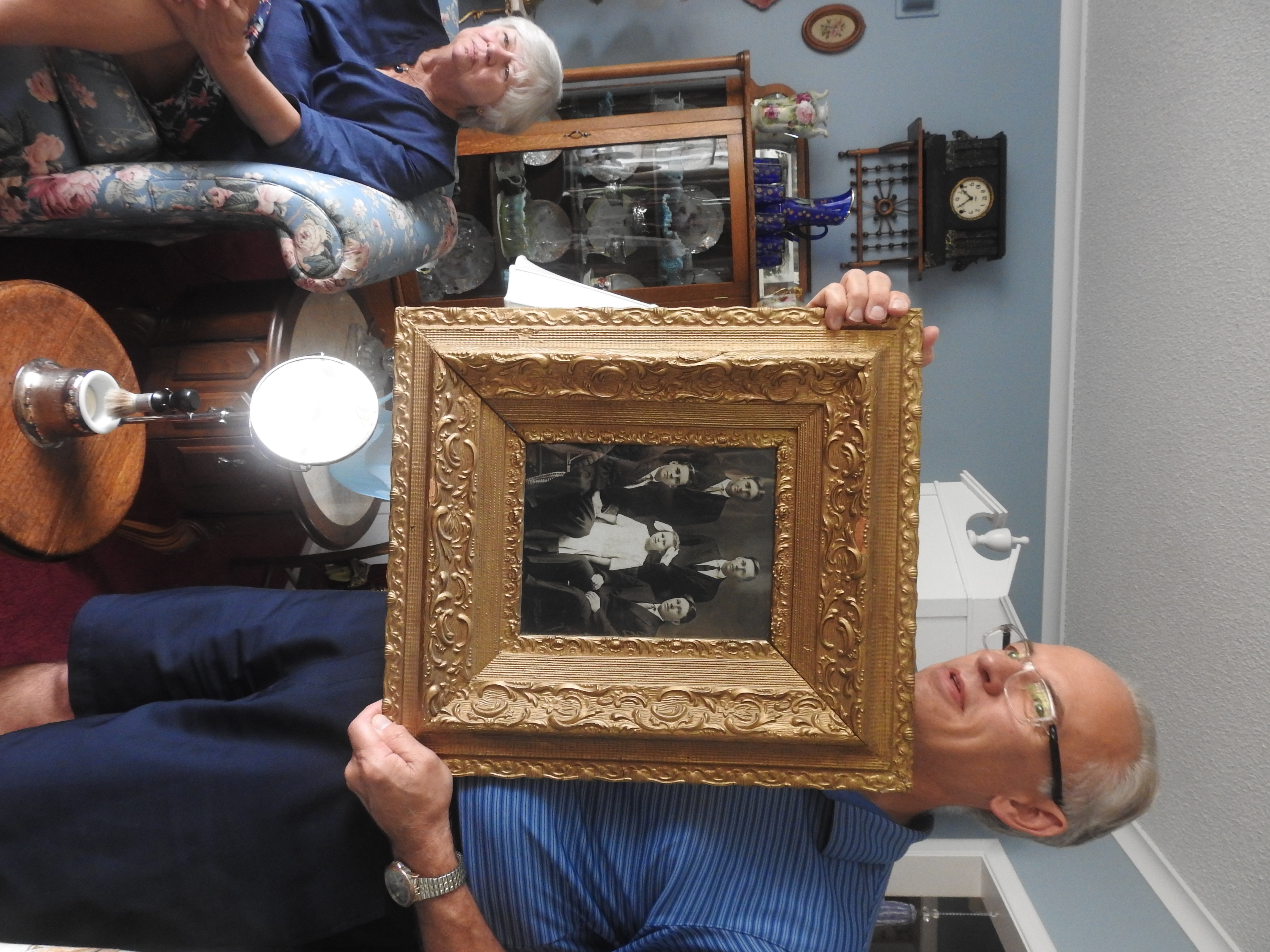 Mark is holding a gold-framed photo of the five surviving children