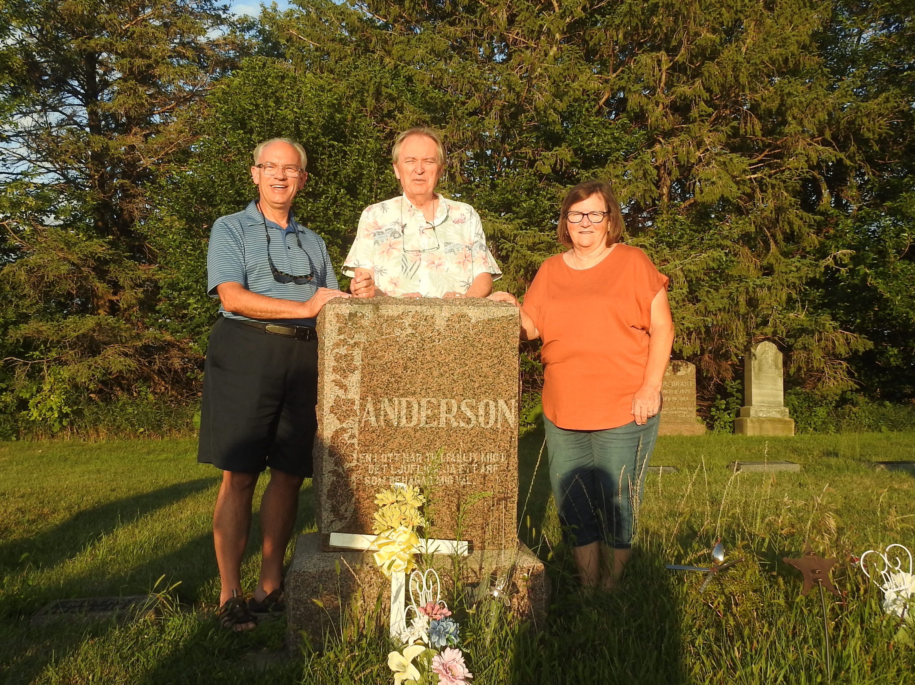 Mark is left of, Mike behind, and Cynthia right of the granite monument