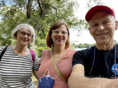 We are standing with a tree and the lake behind us