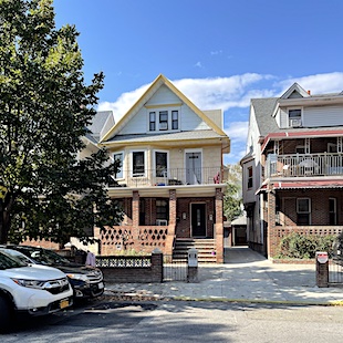 House with brick porch and bay windows in front