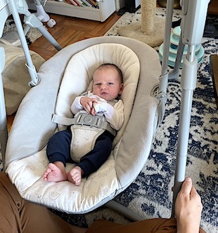 Barefooted baby looks at camera with slight frown