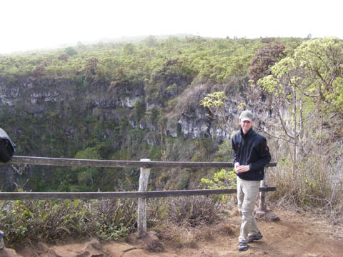 Markus standing at the edge of a large pit formed by a collapsing bubble formed in lava