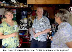 Terri, Donovan, and Gail are standing in the garage with drinks in               their hands. Gail is looking away from the camera. 