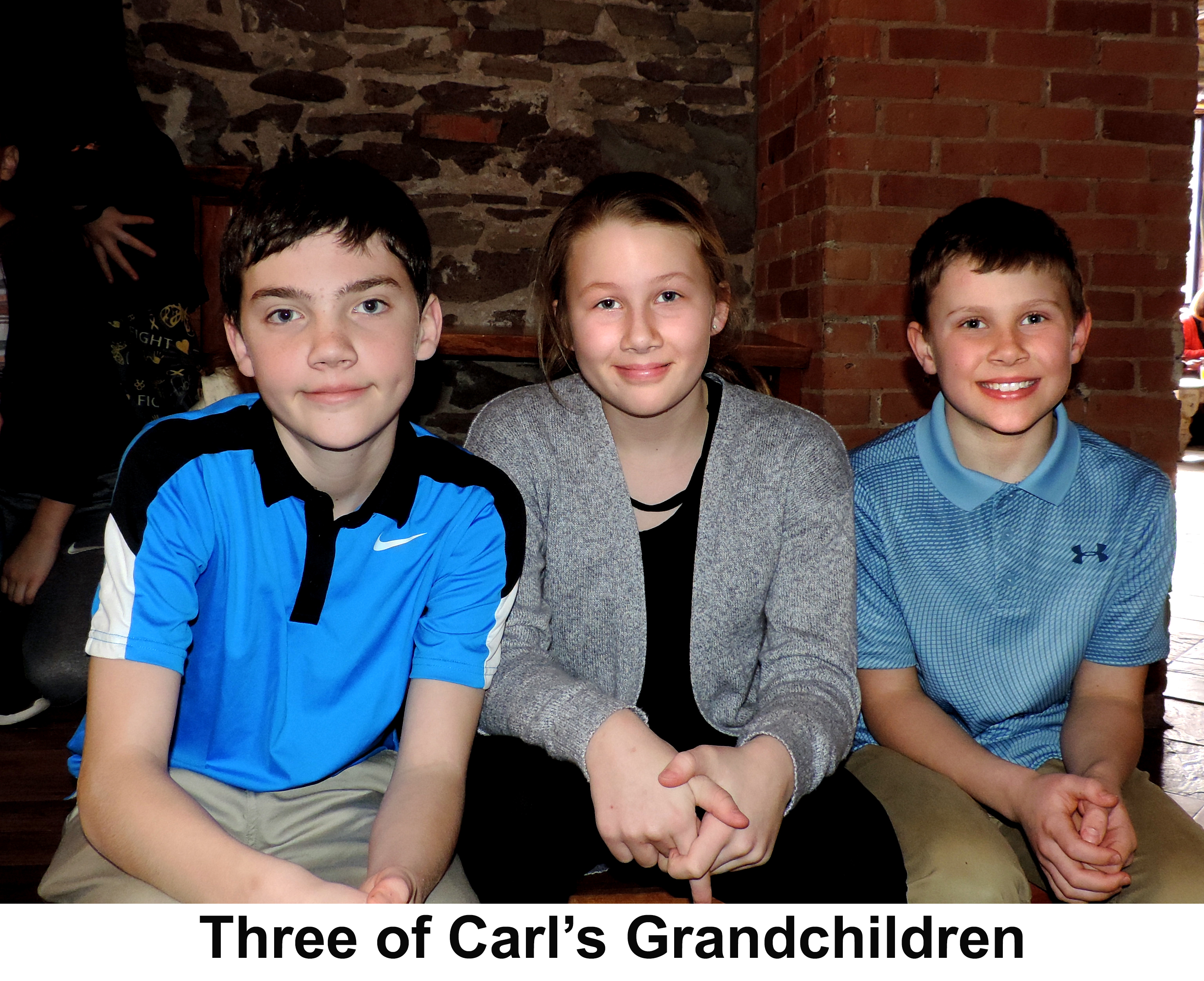 The three are sitting on a bench in a booth at the Ore Dock Brewing Company 
           in Marquette, Michigan.