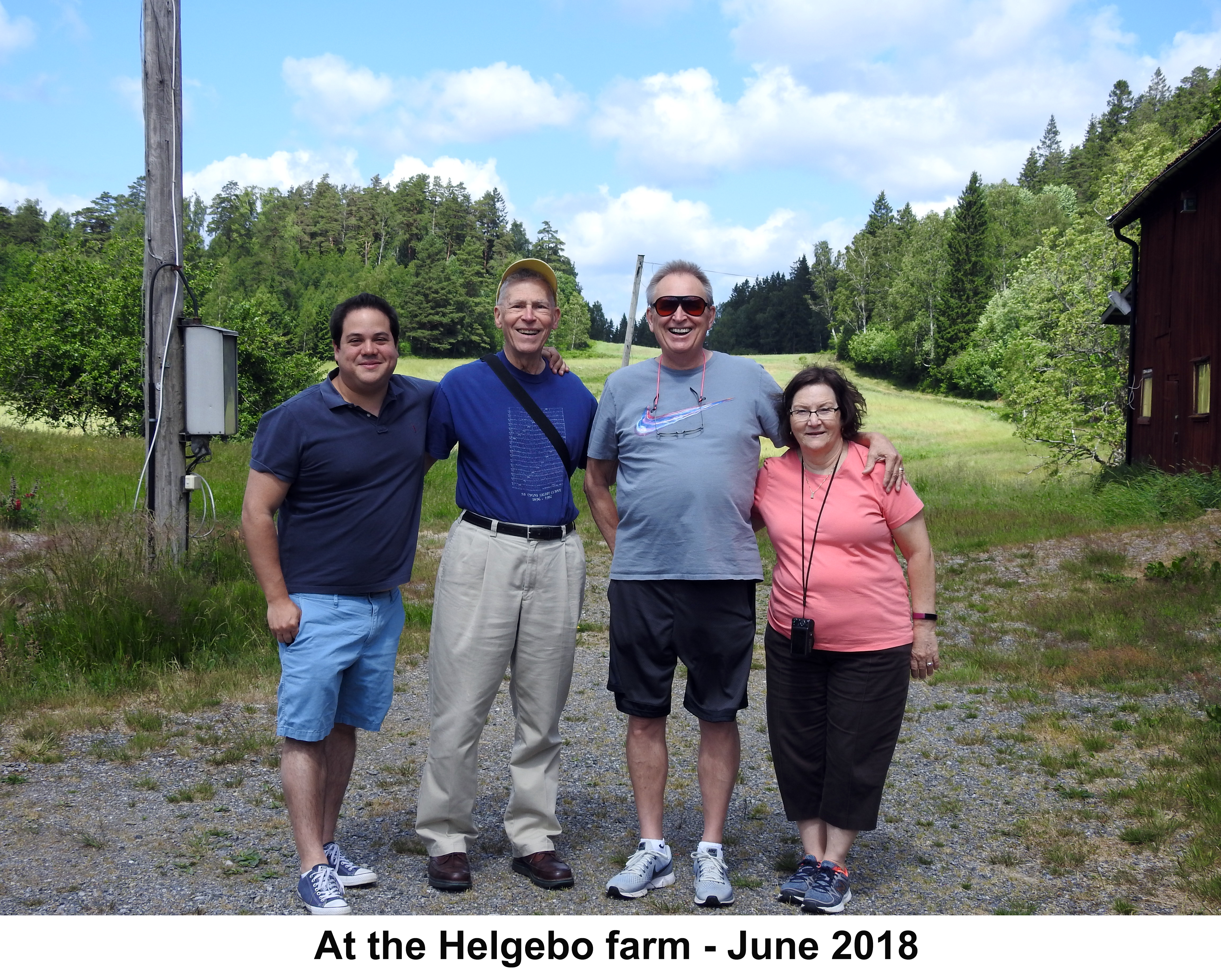 The cousins are standing with the farm field in the background