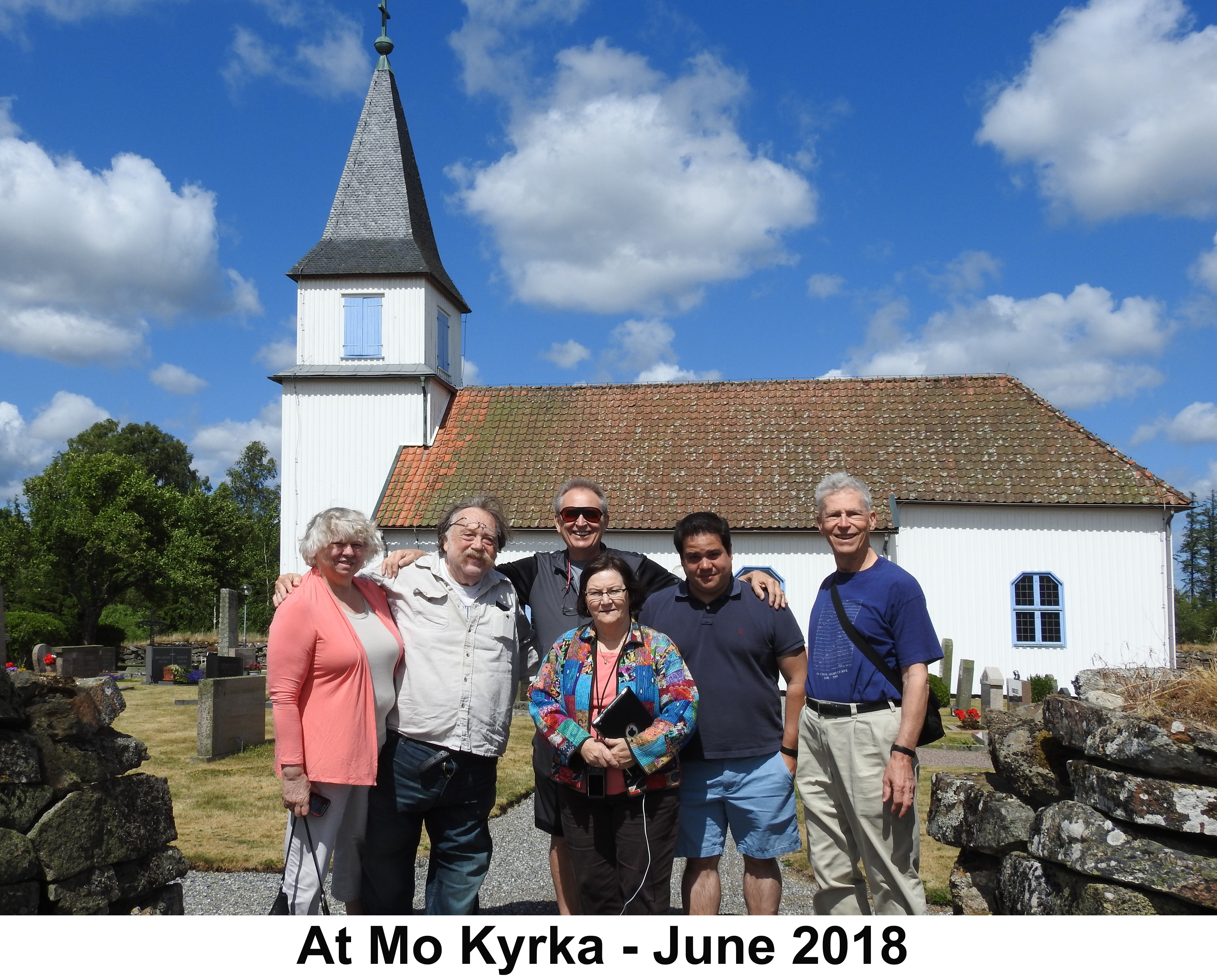 The cousins are standing in the graveyard with the church in the background