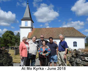 The cousins are standing in the graveyard with the church in the background