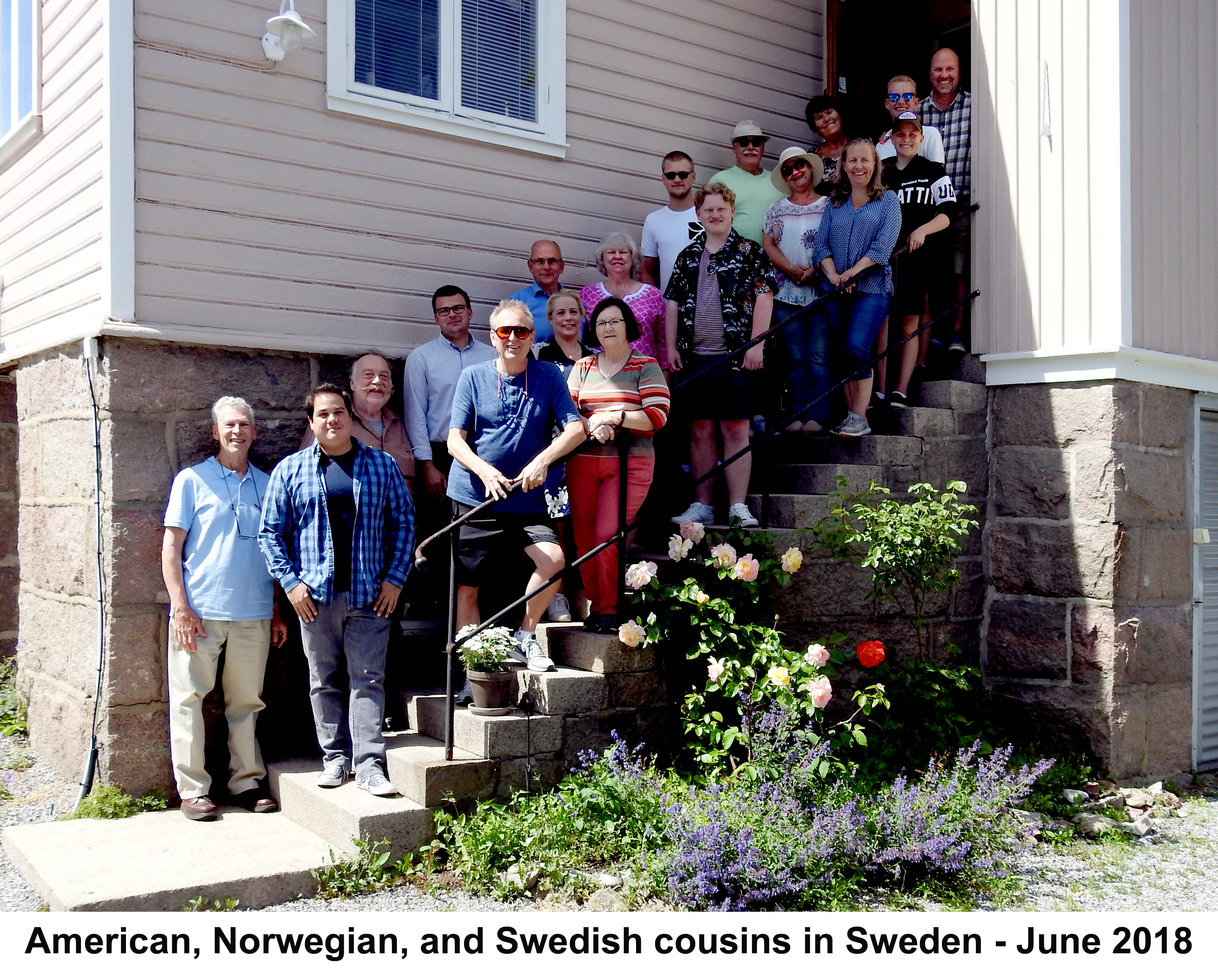 The families are lined up on the stairs that slant up to the right
           above a stone foundation. Sunlight from the left illuminates 
           some of them. 