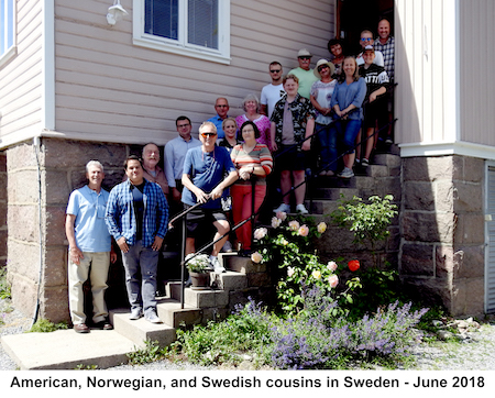 Cousins, spouses, and children standing in a line in front of Michael Holm’s home