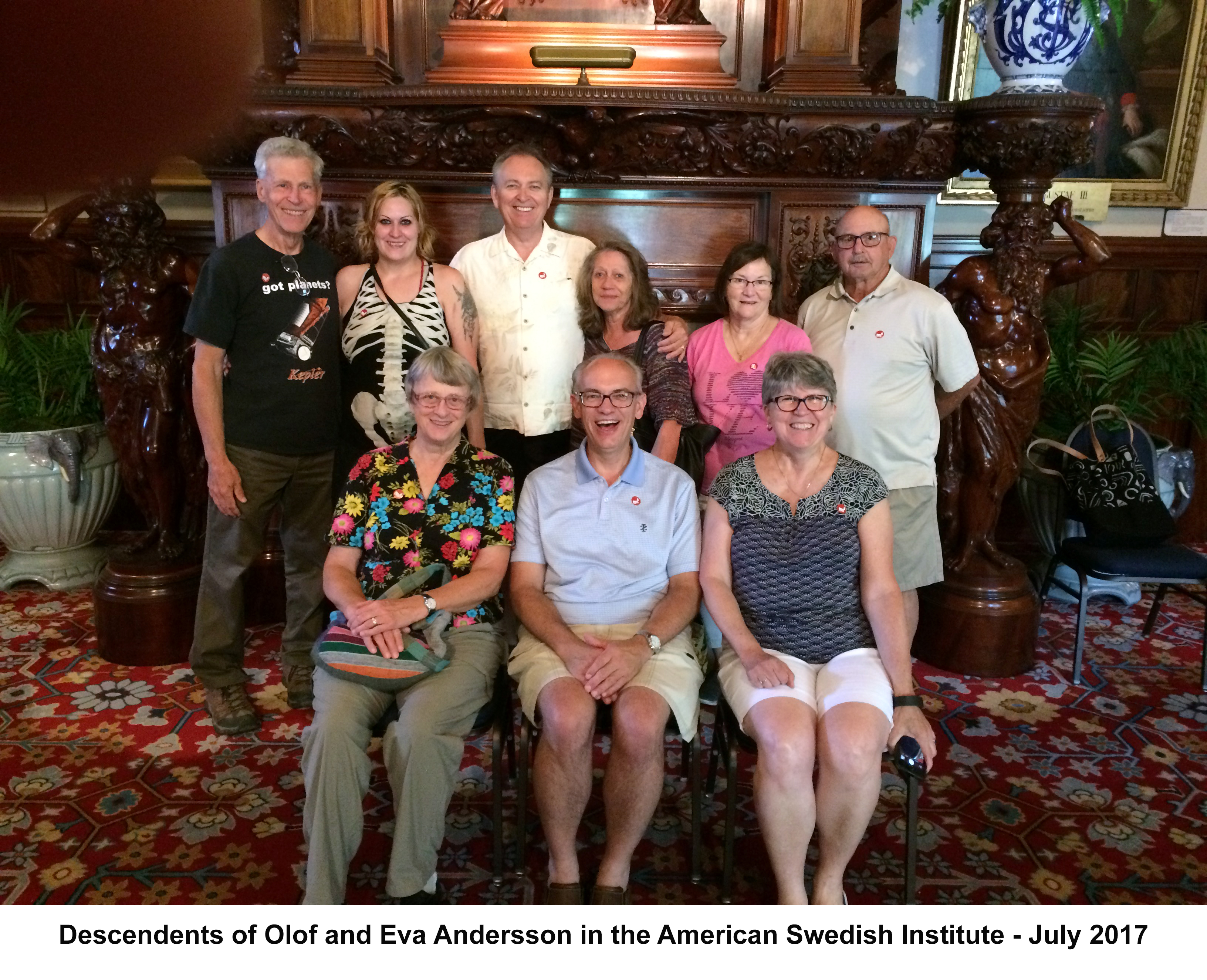 Cousins and spouses, and children in front of 
            the fireplace at the Turnblad Mansion of the American Swedish Institute