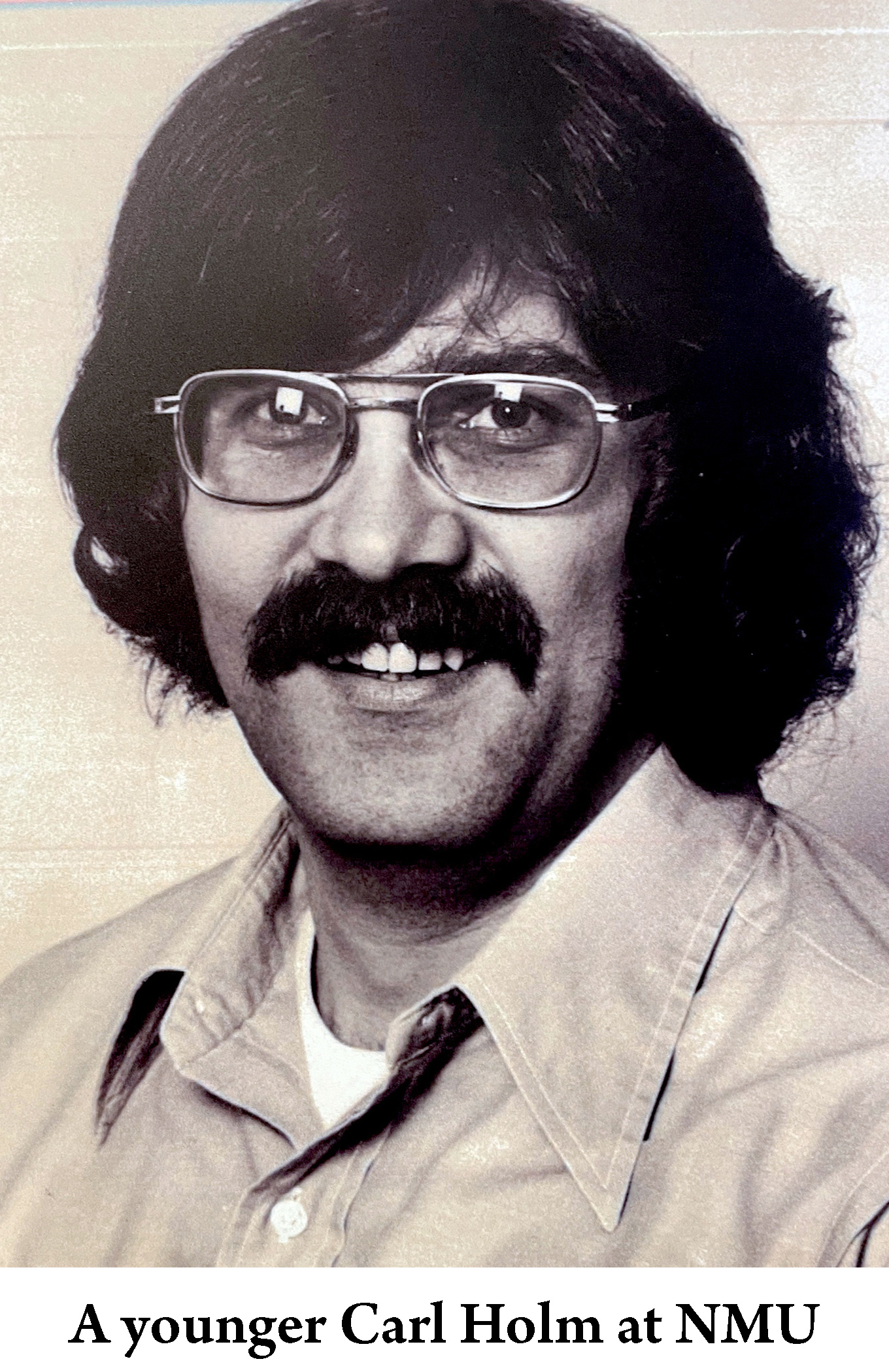 A younger Carl Holm with a big mustache and long hair 