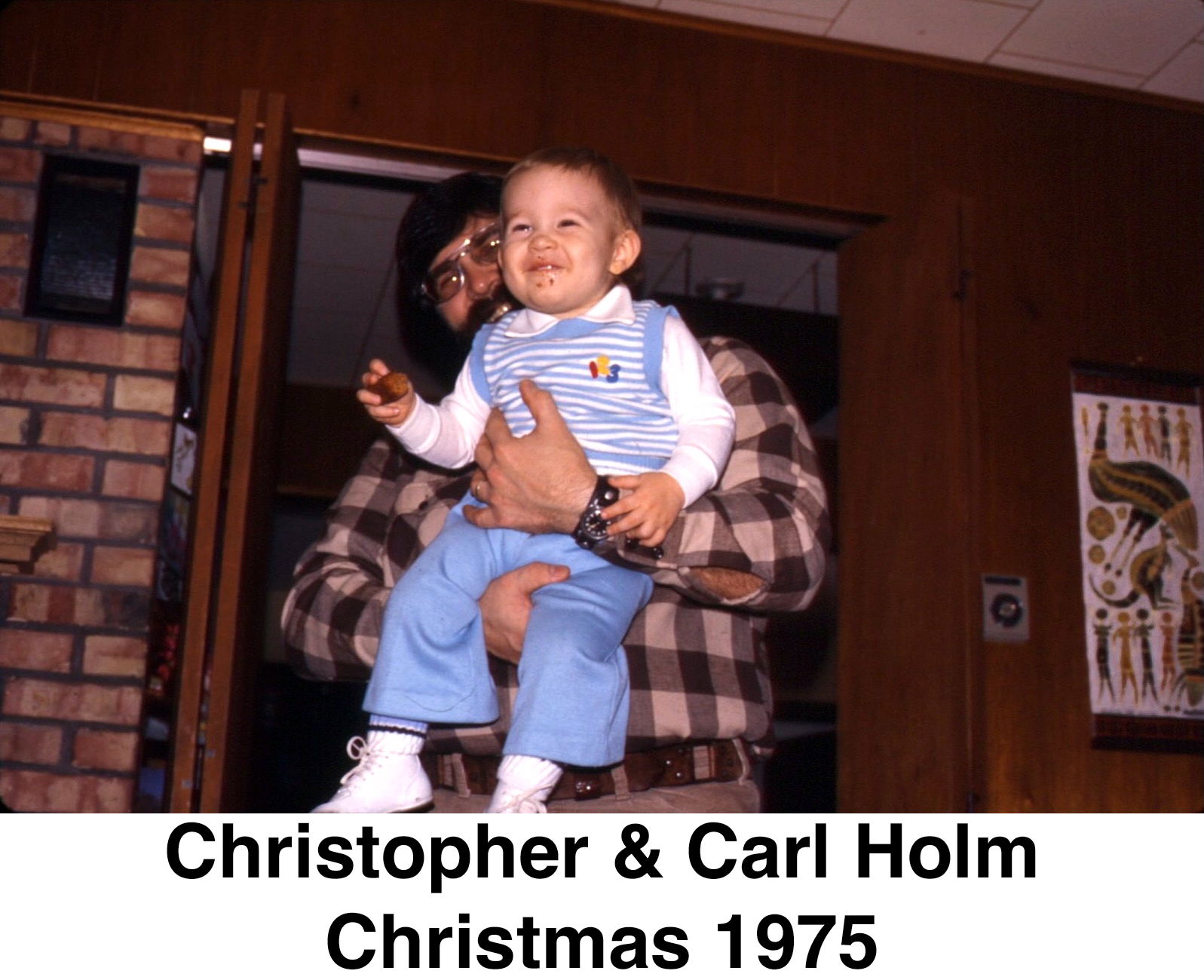 Chris is held by his dad facing outwards