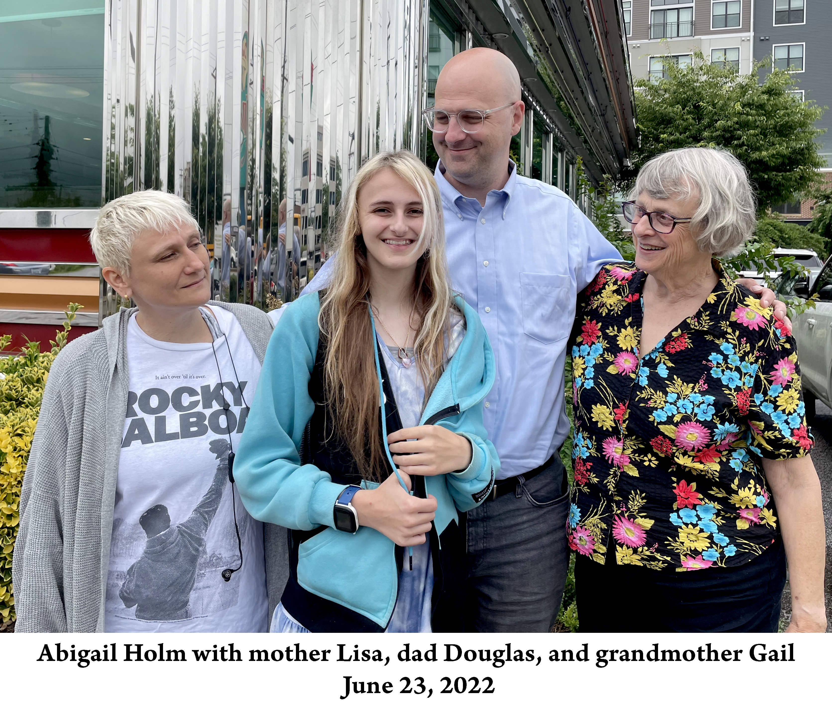 Abby is standing in front of the Double-T Diner with mom, dad, 
          and grandma standing beside her and looking at her