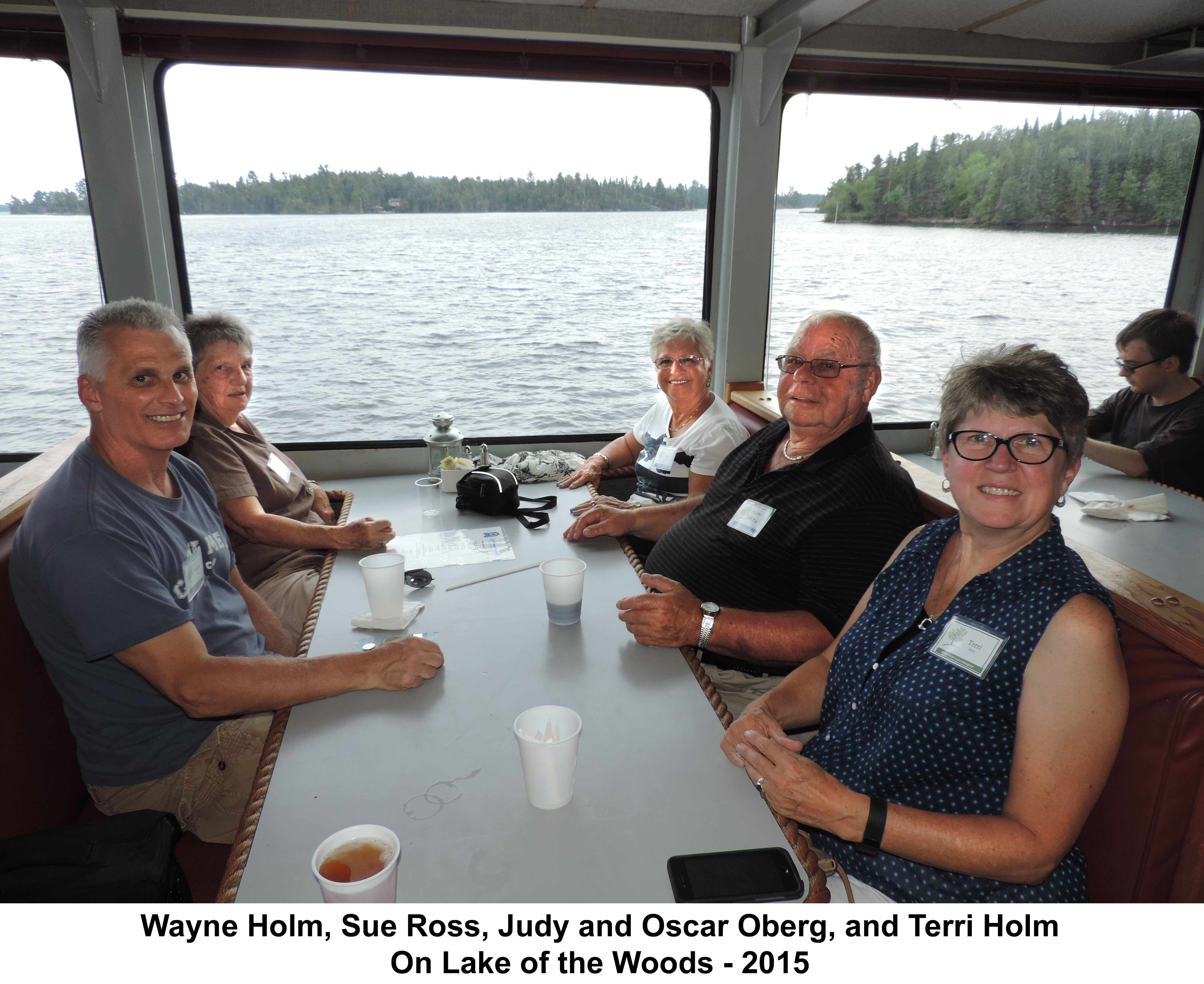 Wayne, Sue, Judy, Oscar, and Terri sitting at a table in front of 
             a window looking out on Lake of the Woods