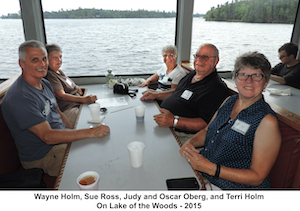 Wayne, Sue, Judy, Oscar, and Terri sitting at a table in front of              a window looking out on Lake of the Woods