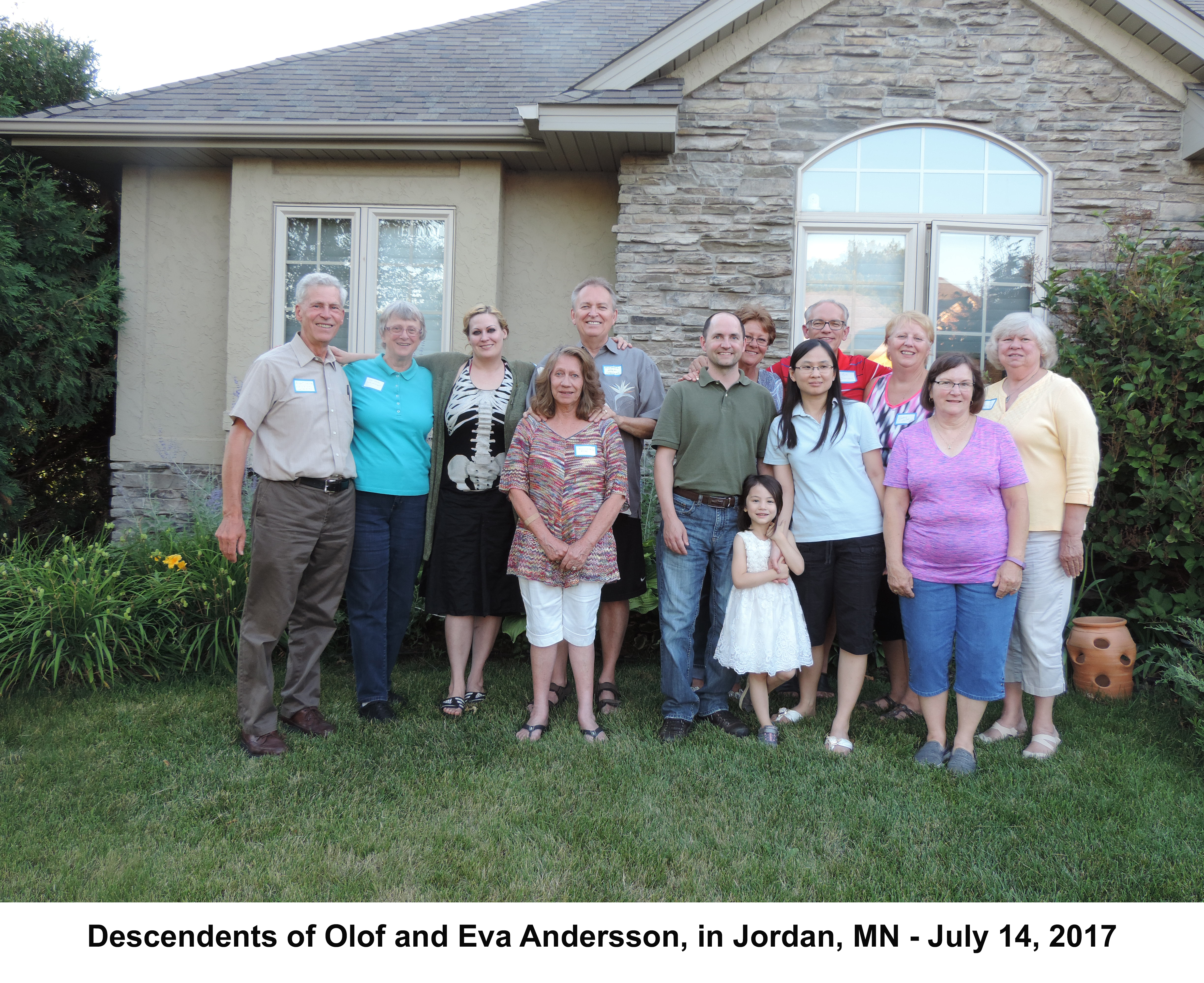 Cousins, spouses, and children standing in a line in front of Michael Holm’s home