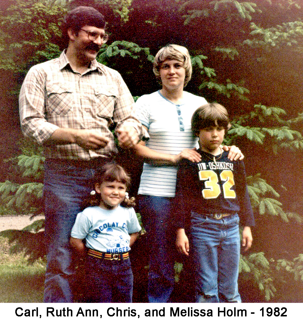 They are standing in front of the evergreen tree in Mom and Murray’s front yard
          in Bates Township