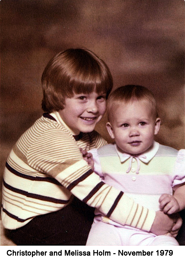 He has a big smile and is holding her in this studio photo.