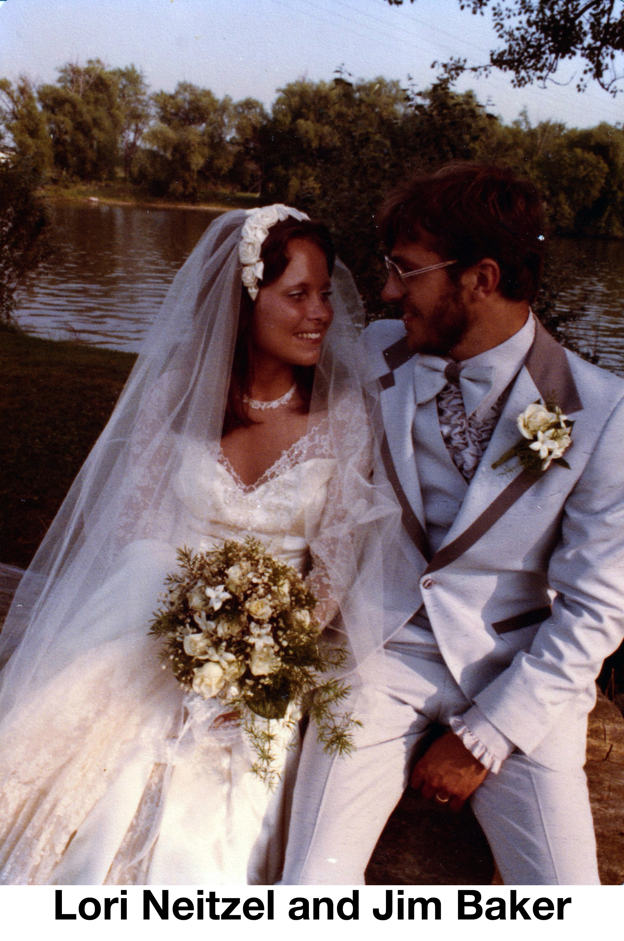 The two are seated in front of a lake and are gazing at each other’s eyes