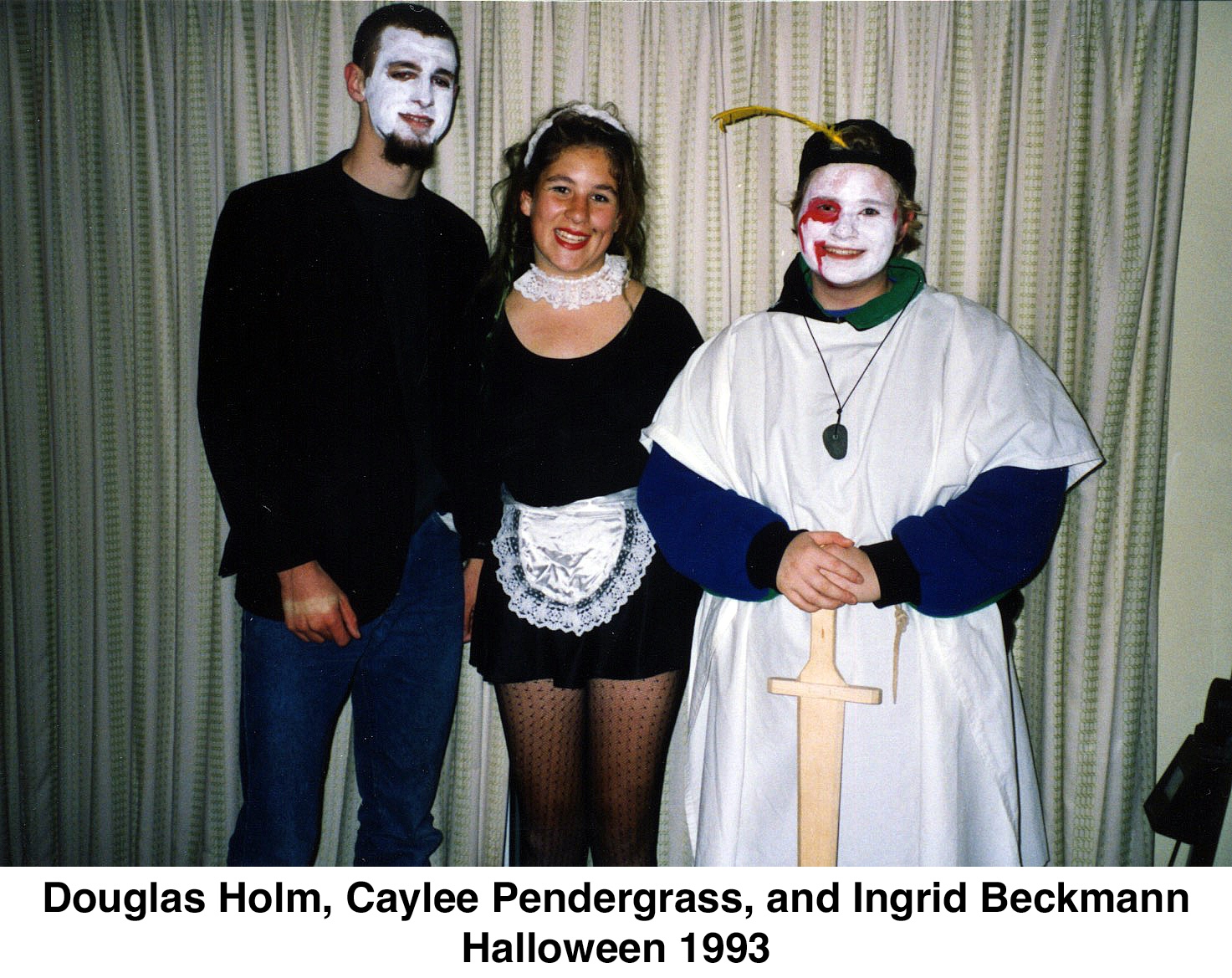 Doug has a white face, Caylee is wearing a short-skirted waitress costume, 
            and Ingrid is wearing a white robe, holding a sword, and has a 
            white face with a red eye.
