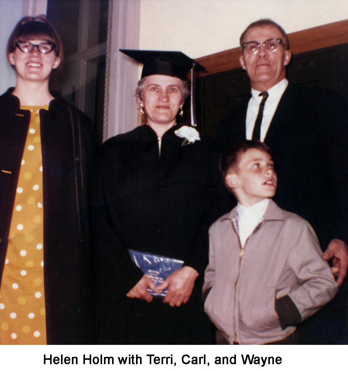 Helen is standing in her robe and mortar board. Carl is wearing 
     a suit and tie.