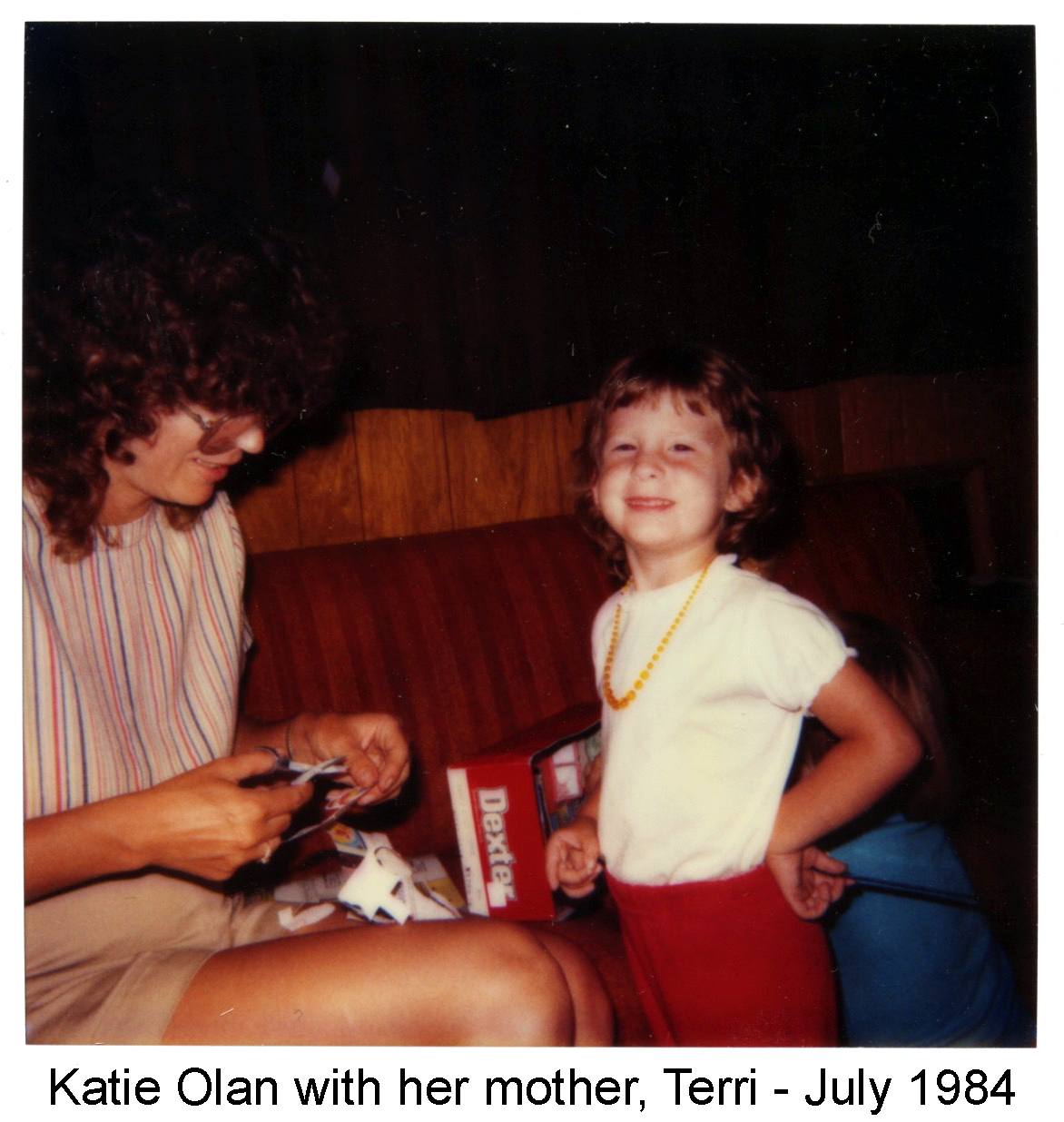 Terri is sitting on the sofa; Katie is standing in front of it and looking at the 
          camera.