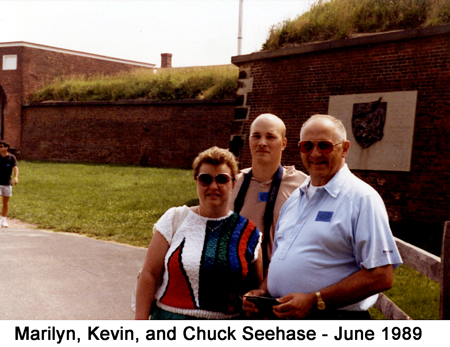 They are standing in front of the outer wall of the fort. 