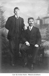 Brothers Carl and Victor Holm in a studio photo. They are dressed in suits with vests.