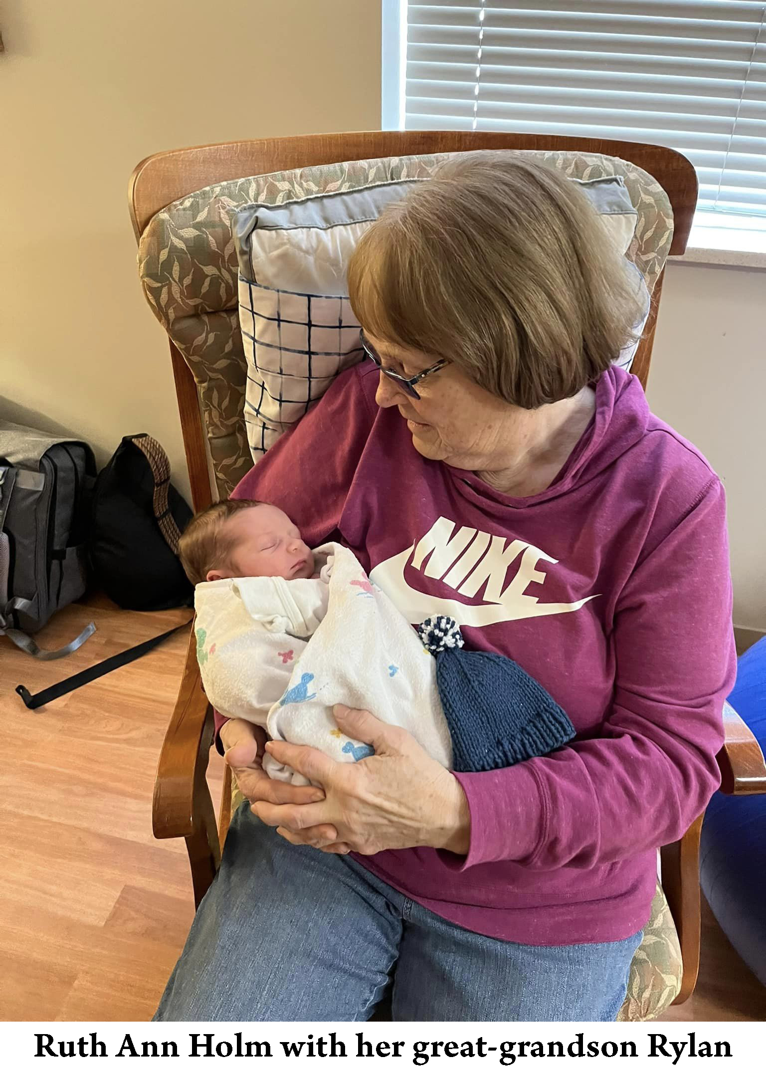Ruth Ann Holm is holding and looking down on her grea-grandson Rylan Holm