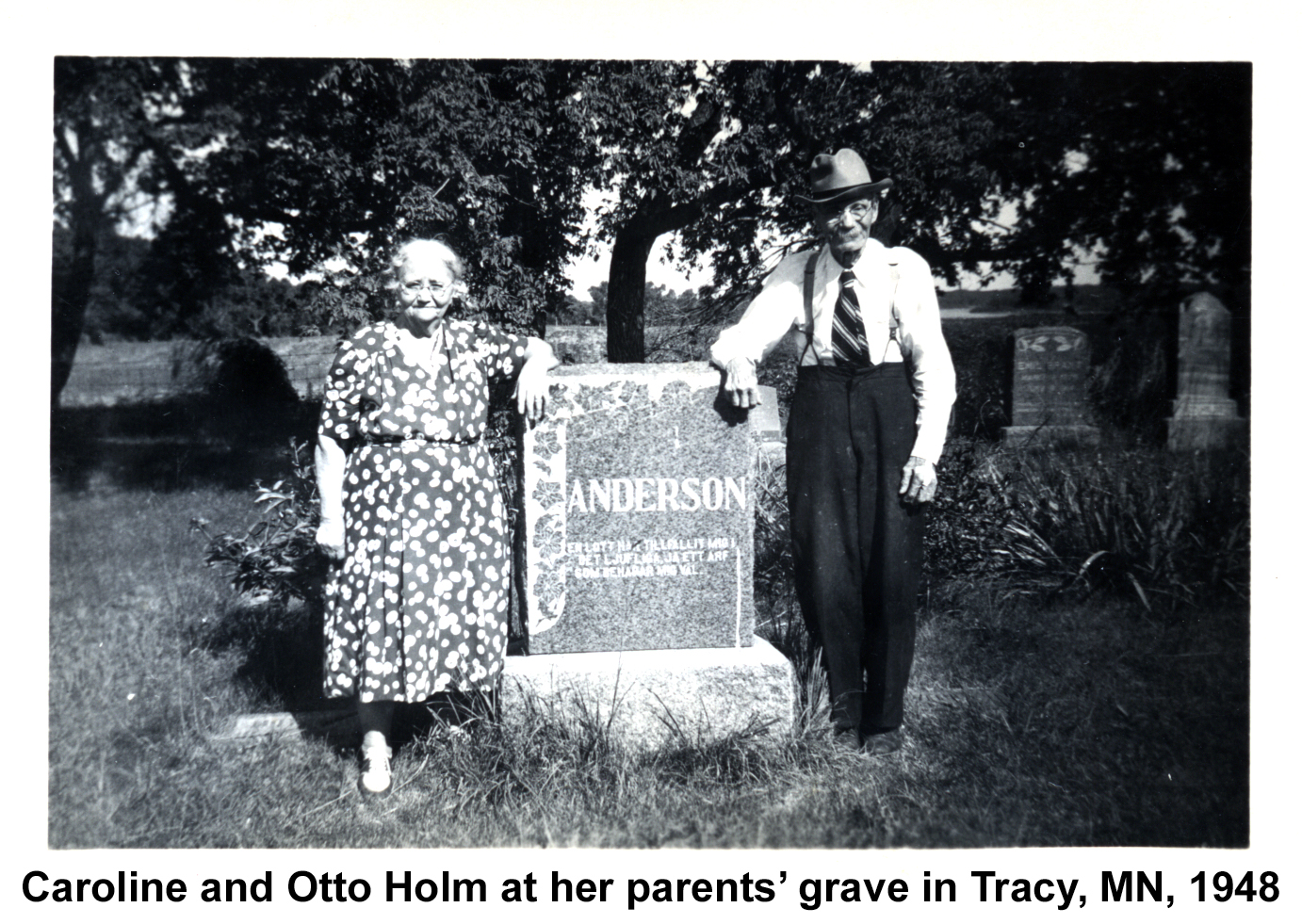 Caroline and Otto Holm are standing on either
       side of a large stone marker for her Anderson parents. The inscription
       is in Swedish