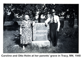 Caroline and Otto Holm standing on either side of            her parents monument in Tracy, Minnesota.