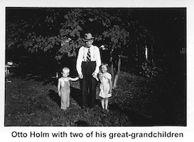 Otto Holm standing and holding the hands of his                great-grandchildren, Dick Schons and Joanne Schons.
