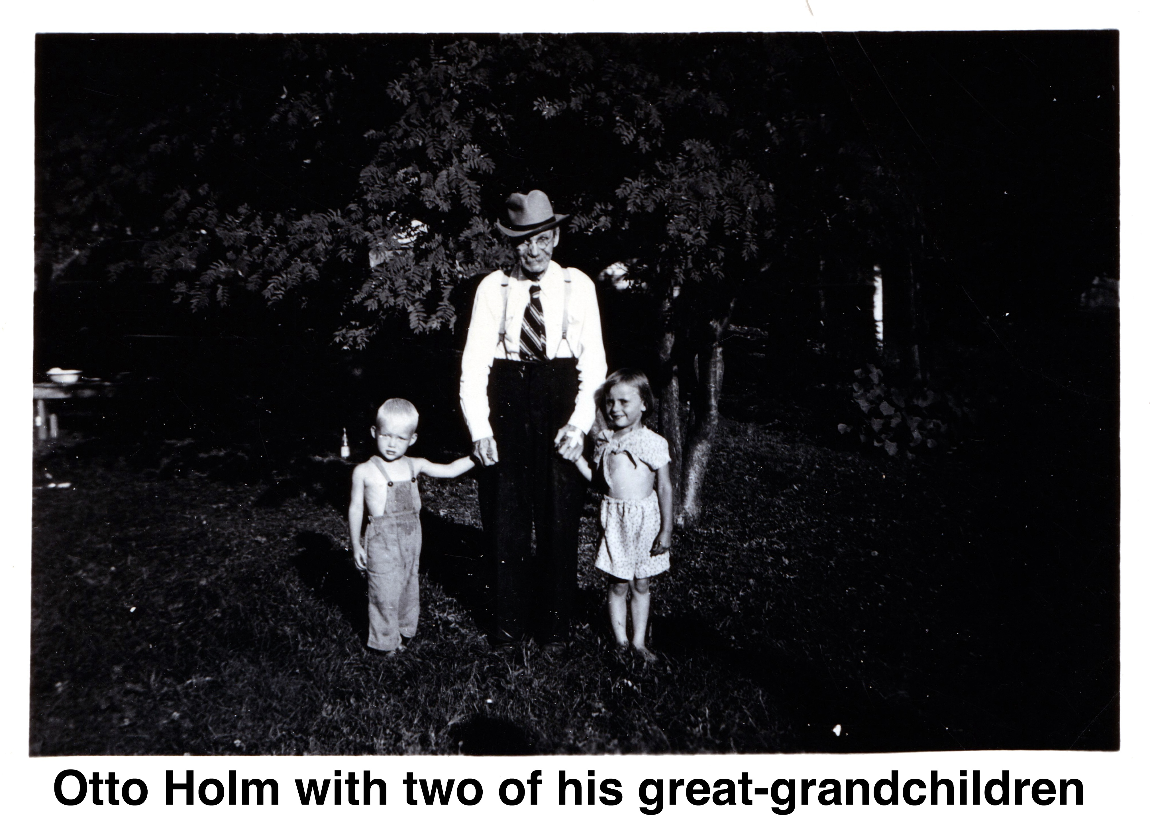 Otto Holm standing and holding the hands of his 
       great-grandchildren, Dick Schons and Joanne Schons.