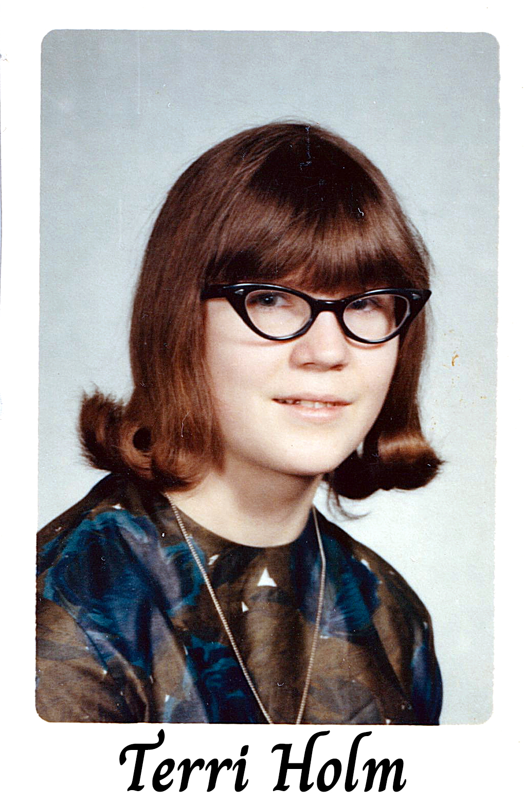 A color school photo of Terri Holm with glasses and long hair