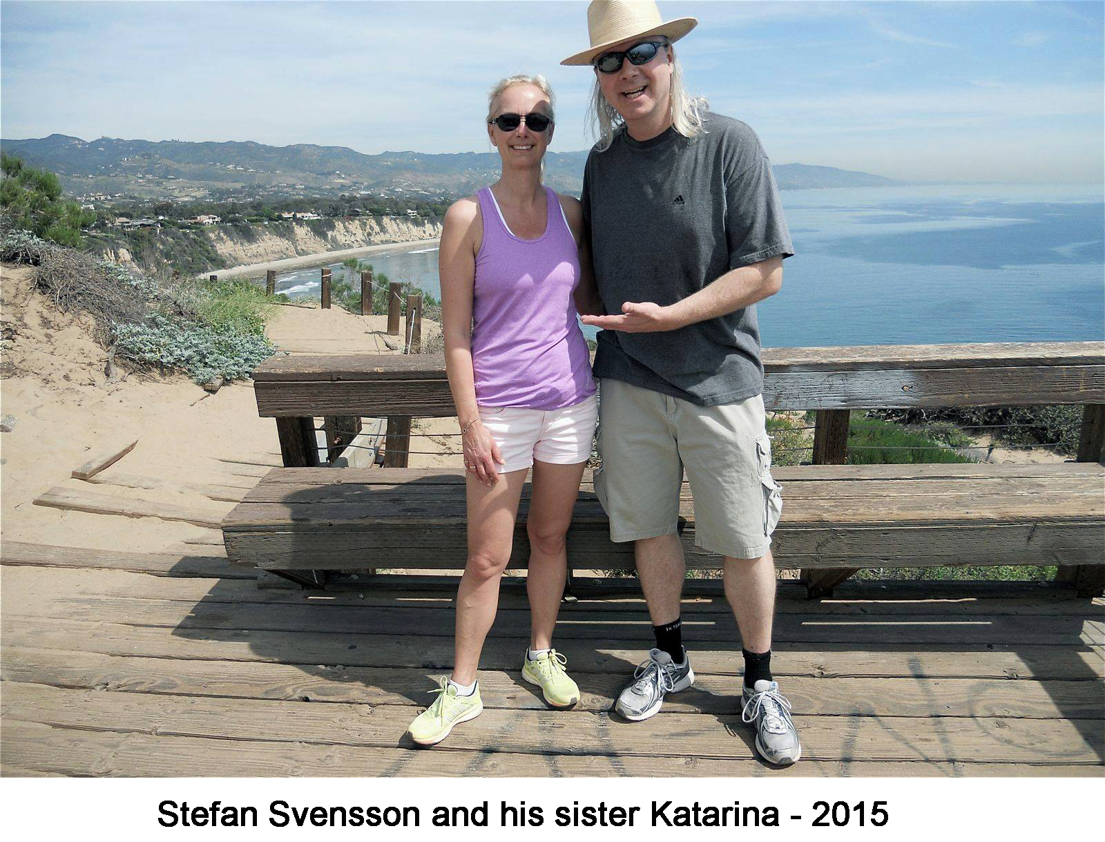 The two are standing on the heights overlooking a shore.