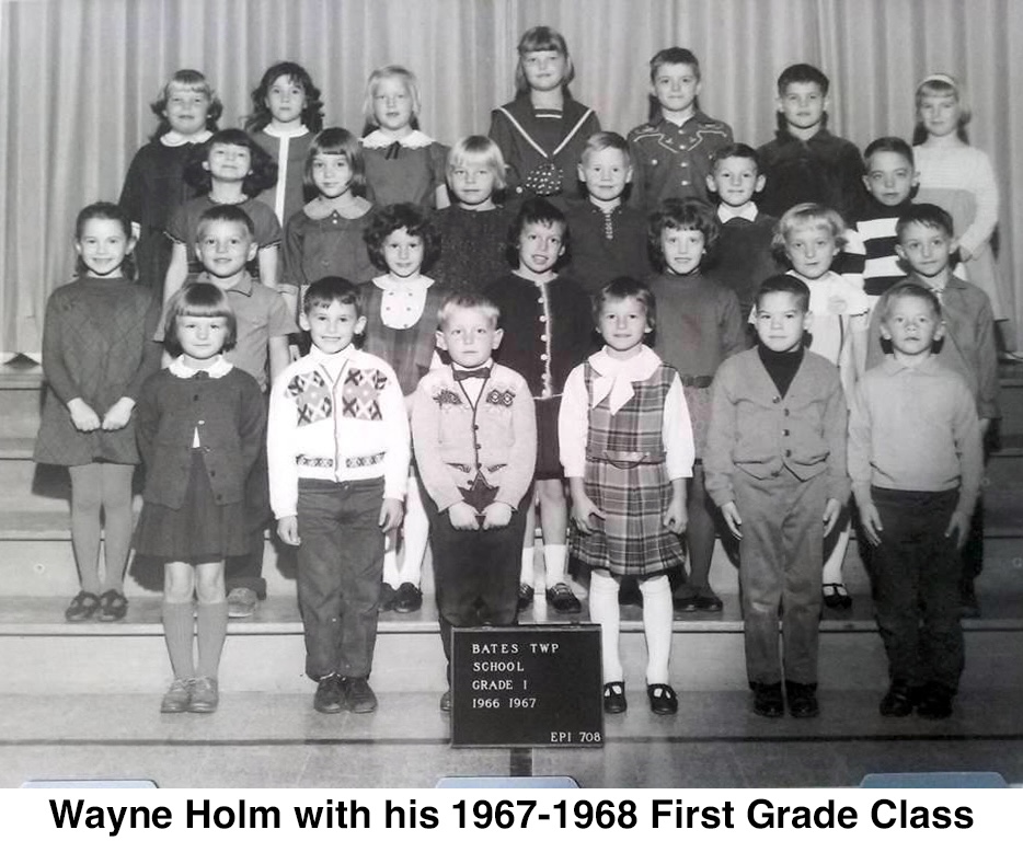 The pupils are standing in rows on the bleachers facing the camera