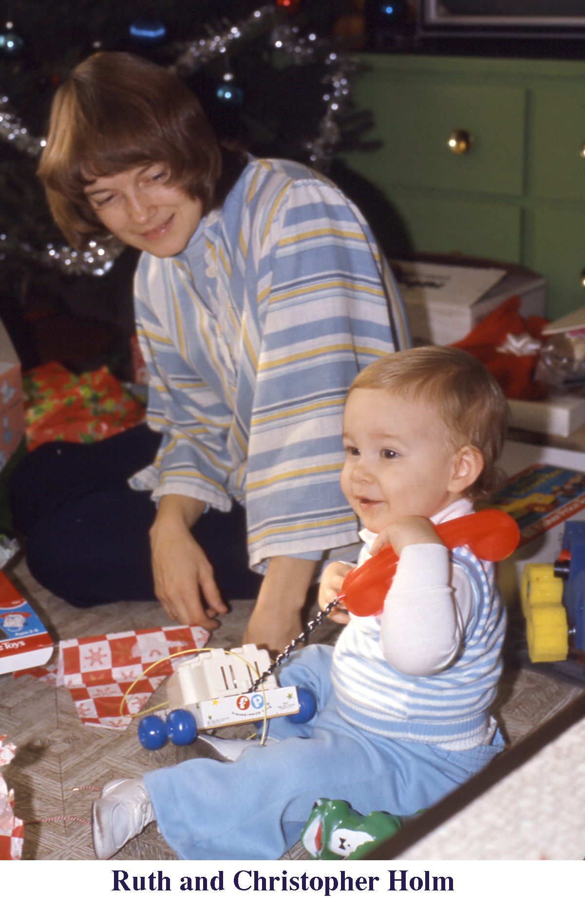 Ruth and Chris Holm with a toy FP phone by the tree at Christmas 1975