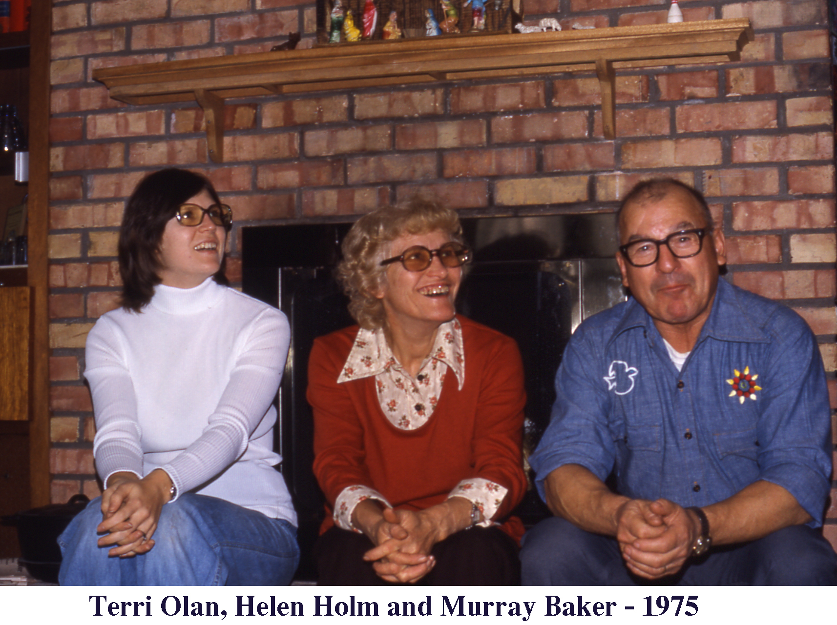Terri Olan, Helen Holm and Murray Baker sitting in front of the 
      fireplace at Christmas 1975