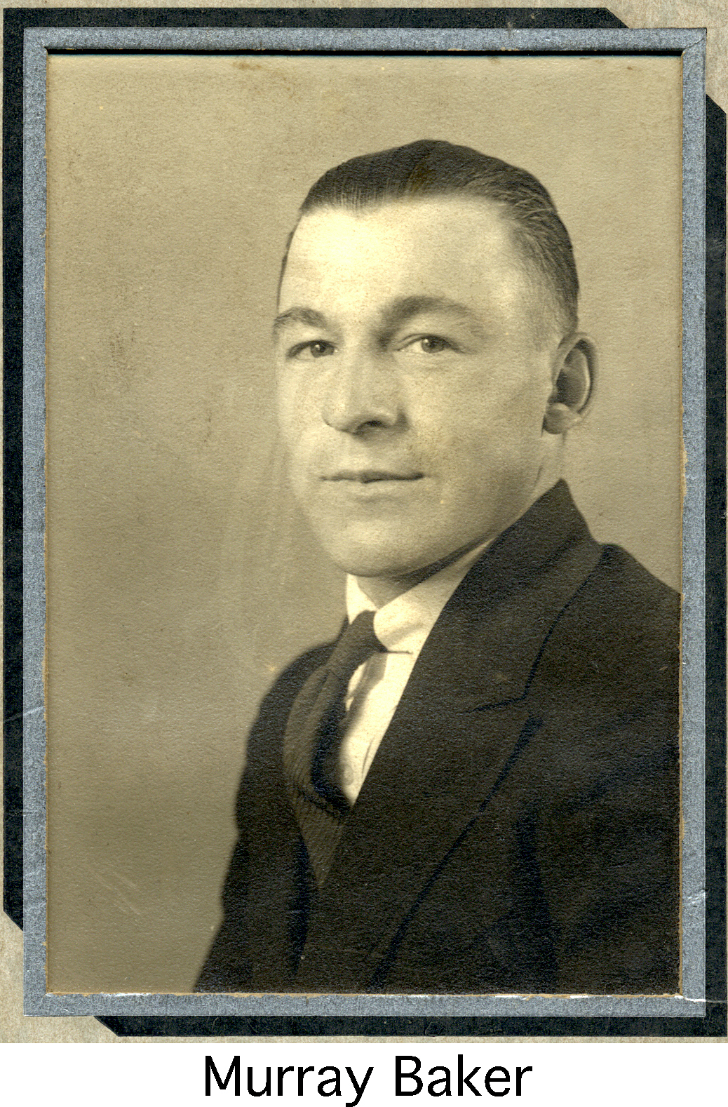 Murray Baker wearing a dark coat and tie in a formal photograph