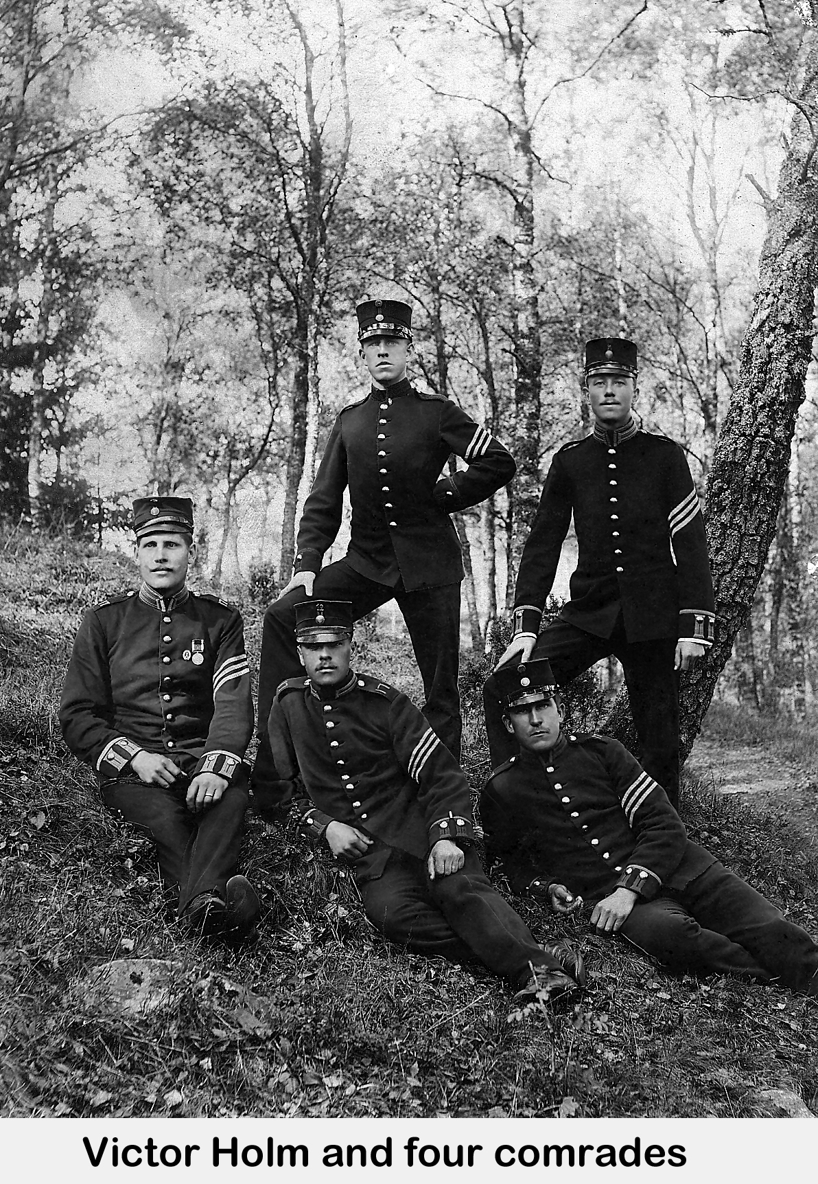 Victor seated on the ground with four other sargents, in a forest