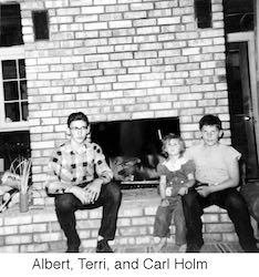 Albert, Terri, and Carl Holm sitting on fireplace