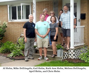 The family group is standing in front of Ruth Ann’s front door