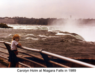 Carolyn Holm standing at the railing by the Niagra River where it flows 
                over the falls