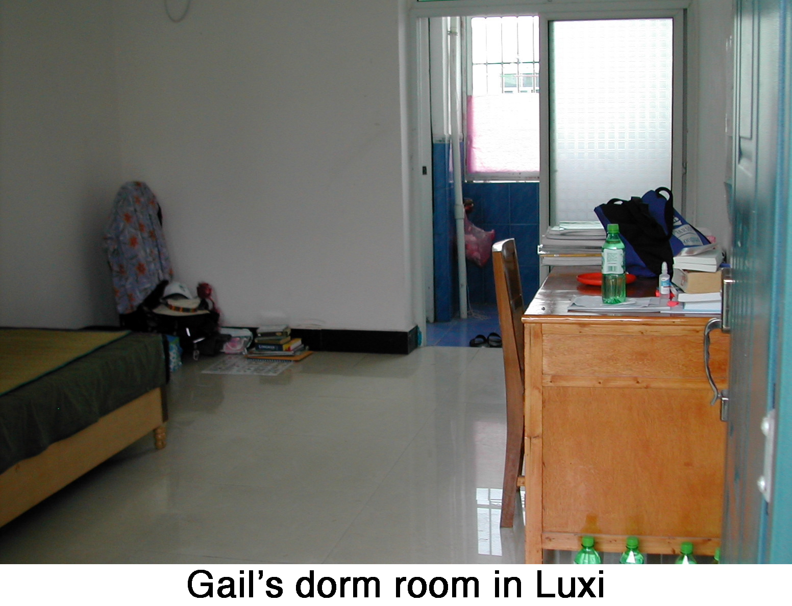 Gail’s room at Luxi, a bed, a wooden desk, and a bathroom