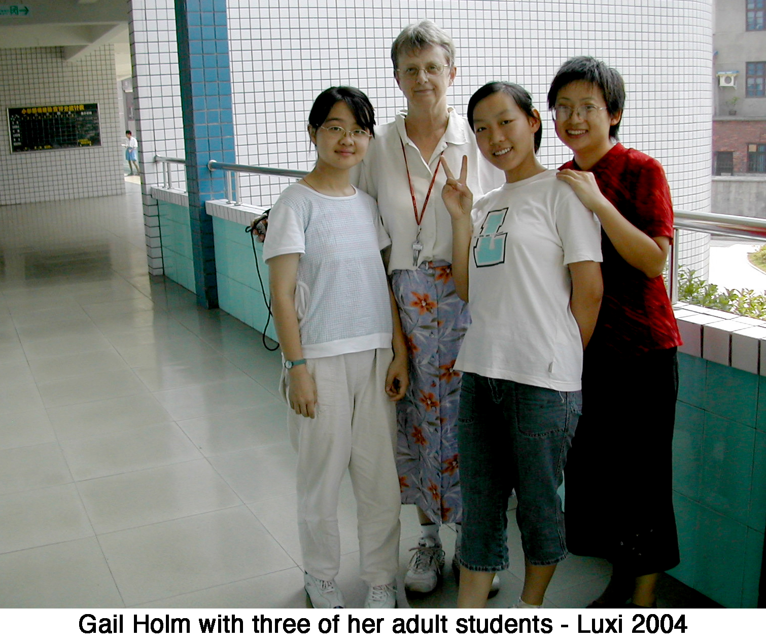 Gail standing in a hall with three adult students