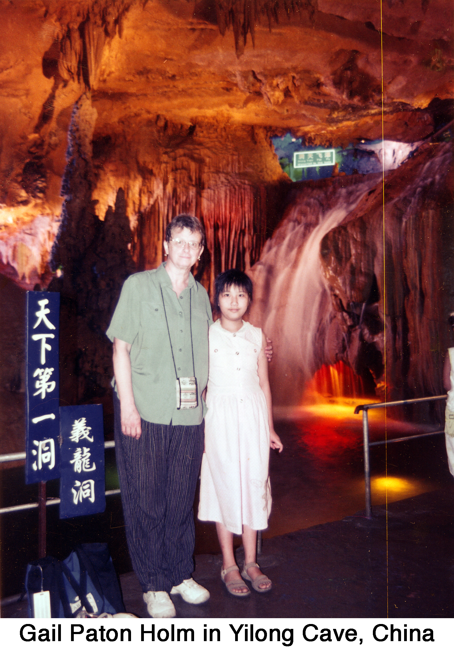 Gail Holm standing with a student in front of colorfully lit rock formations